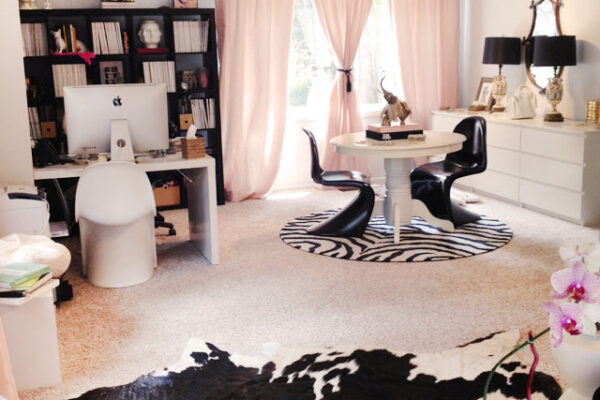 home office with ikea expedit desk shelving unit, grey walls, pink curtains, cowhide rug, bloggers offices