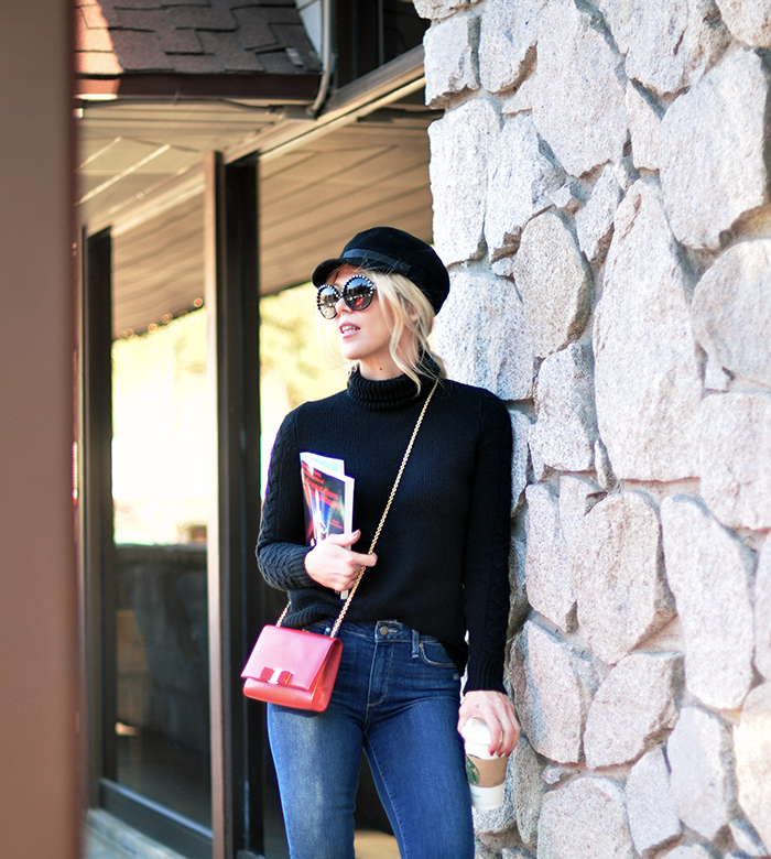 retro casual 60s style, big round embellished sunglasses, jeans and a turtleneck, red cross body bag, loafers, casual street style