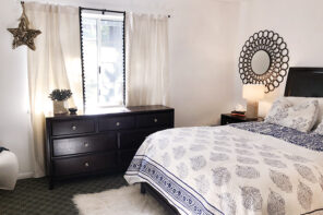 blue and white guest room with dark wood furniture