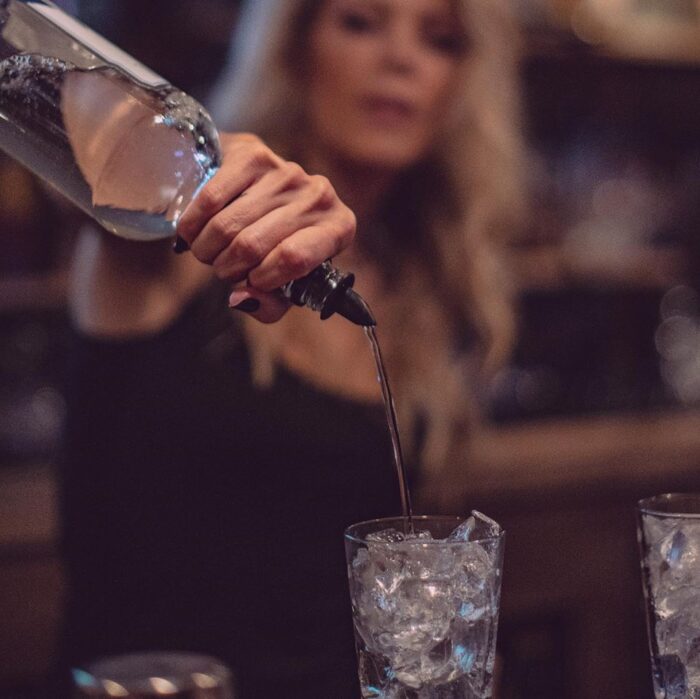 female bartender pouring a drink - dogwood tavern lake arrowhead maegan tintari