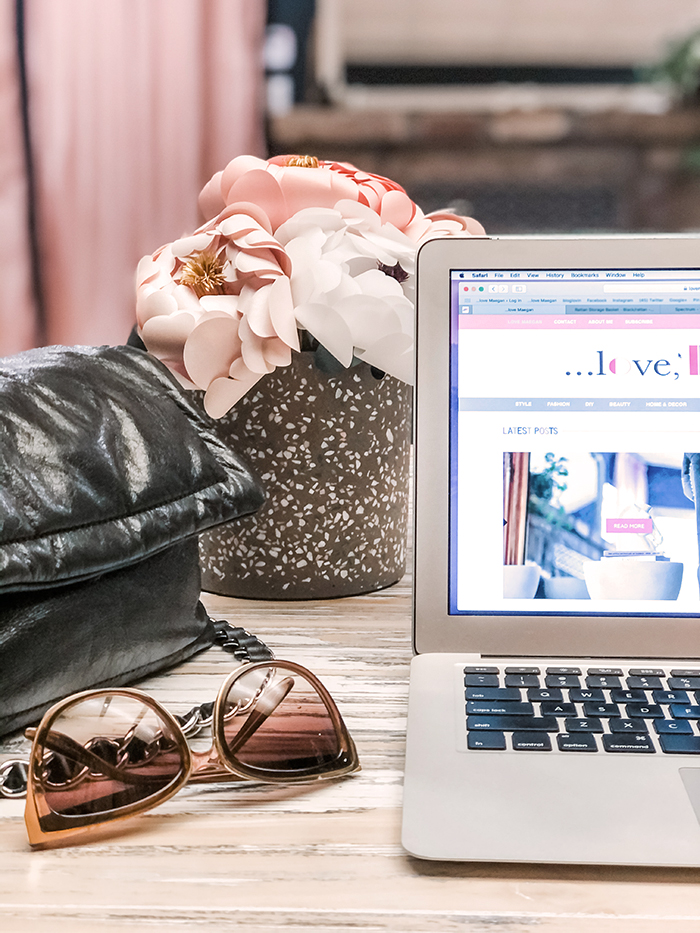 pretty in pink office, laptop with pot of flowers, bag and sunglasses