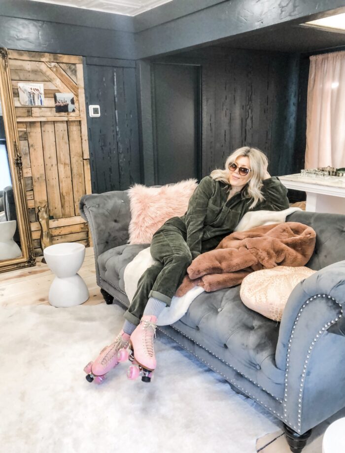 sitting on a couch, grey tufted sofa, corduroy coveralls jumpsuit, pink roller skates, love maegan's office