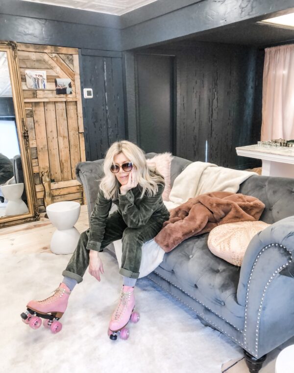 sitting on a couch, grey tufted sofa, corduroy coveralls jumpsuit, pink roller skates, love maegan's office