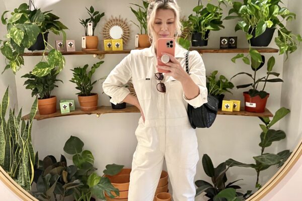 selfie in round mirror with plants in the background, ivory coveralls, lee unionalls, love maegan, blonde messy bun, lake arrowhead, shopping in lake arrowhead, bohemian village boutique
