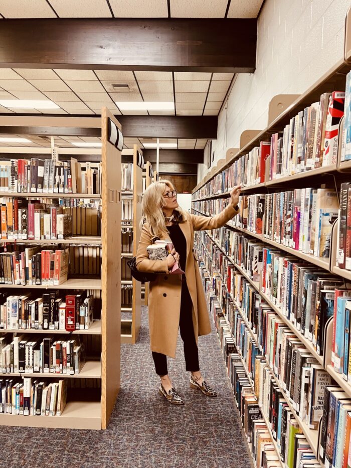 in the library, library books, books, library aesthetic, camel coat, snakeskin loafers, black outfit, faux leather pants, library style, fall style, lake arrowhead library, blonde with glasses, in the library