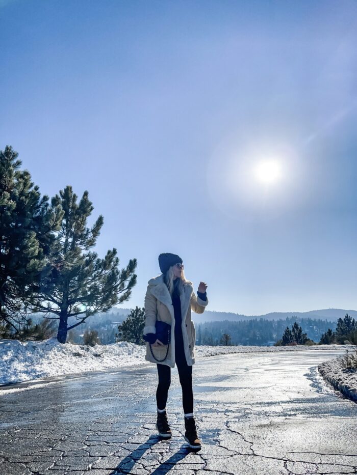 snow style, casual outfit in the snow, winter style, style over 40, cute ways to wear leggings, winter boots, sorels, faux shearling jacket, lake arrowhead, tree lined street