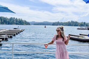 woman in a pink puffy dress with white classic clogs standing on the lake arrowhead docks at the marina in front of the blue lake water and cloudy sky at dogwood dockside jake's on the lake