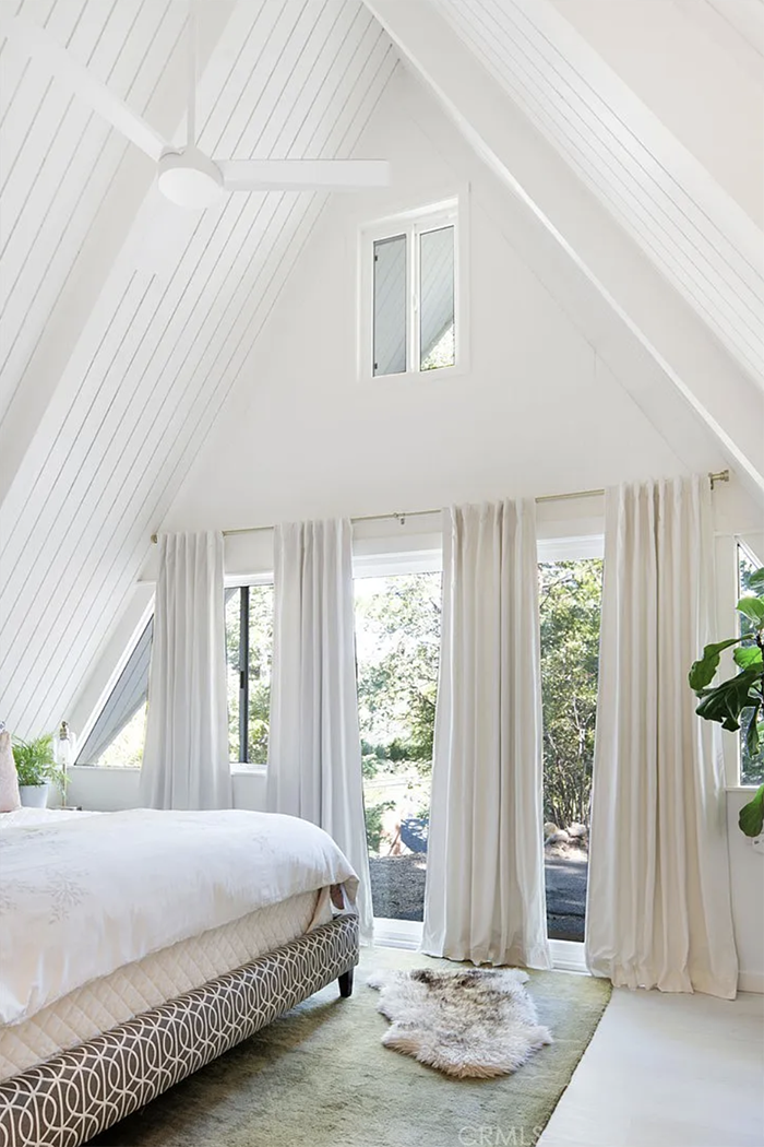 white a-frame bedroom with curtains