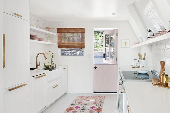 white and pink kitchen with gold hardware