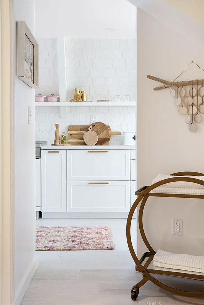 white and pink kitchen with gold hardware