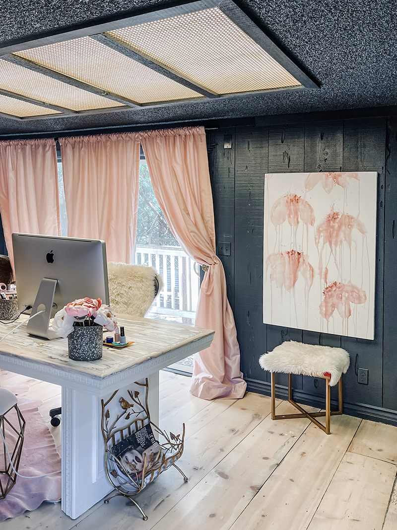 large art canvas with blush pink dripping flowers on dark navy walls in office with pink curtains