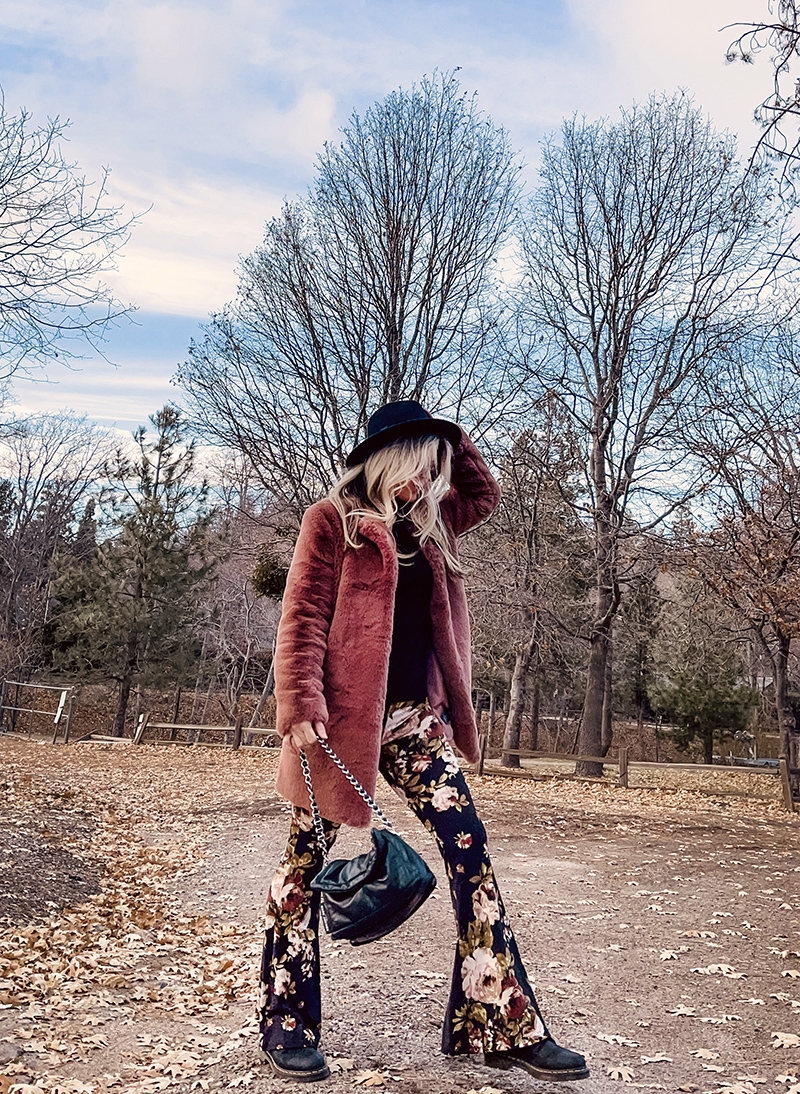 70s boho style, flared bell bottom floral pants with a black turtleneck, faux fur coat and doc martens