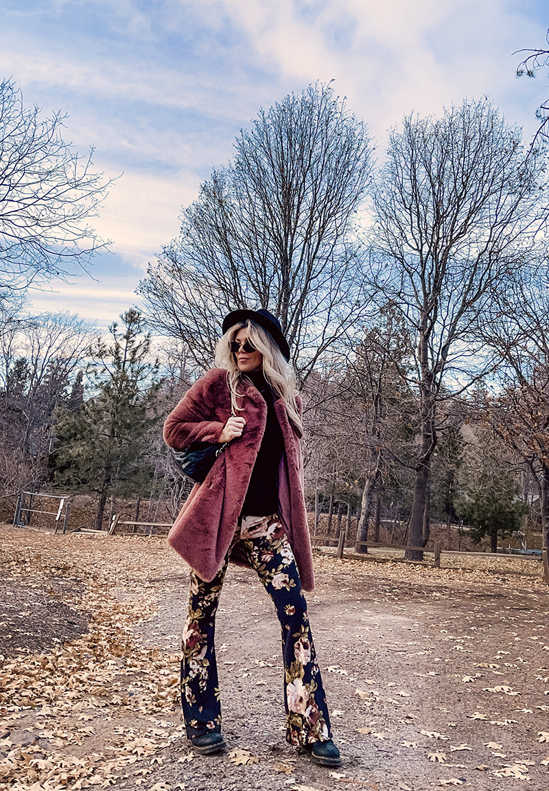 70s boho style, flared bell bottom floral pants with a black turtleneck, faux fur coat and doc martens