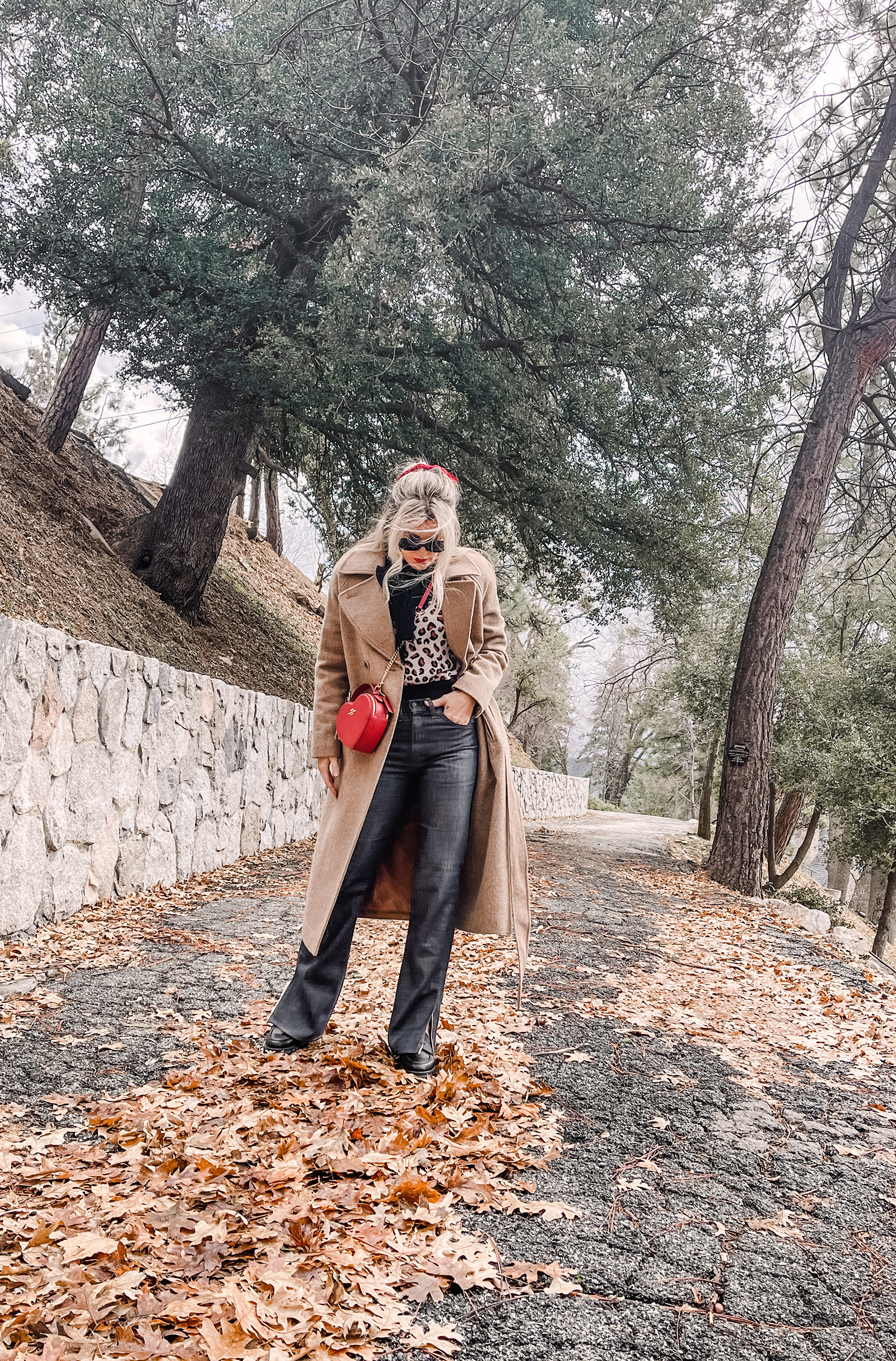 red heart shaped coach bag for valentine's day, casual outfit, vintage levis jeans with a hem slit, chunky loafers, leopard print sweater, red ribbon in her hair, blonde waves, casual winter style