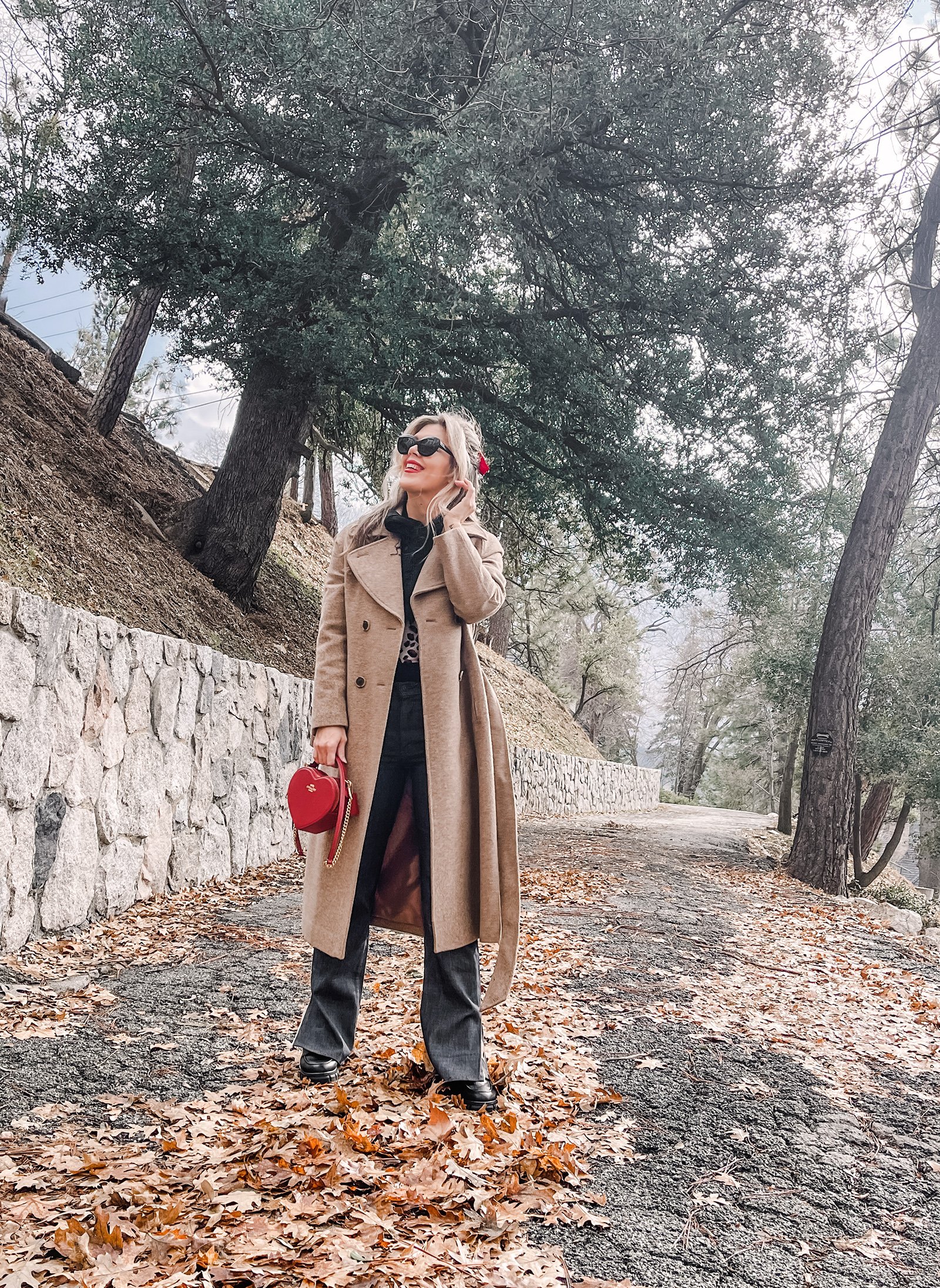 red heart shaped coach bag for valentine's day, casual outfit, vintage levis jeans with a hem slit, chunky loafers, leopard print sweater, red ribbon in her hair, blonde waves, casual winter style