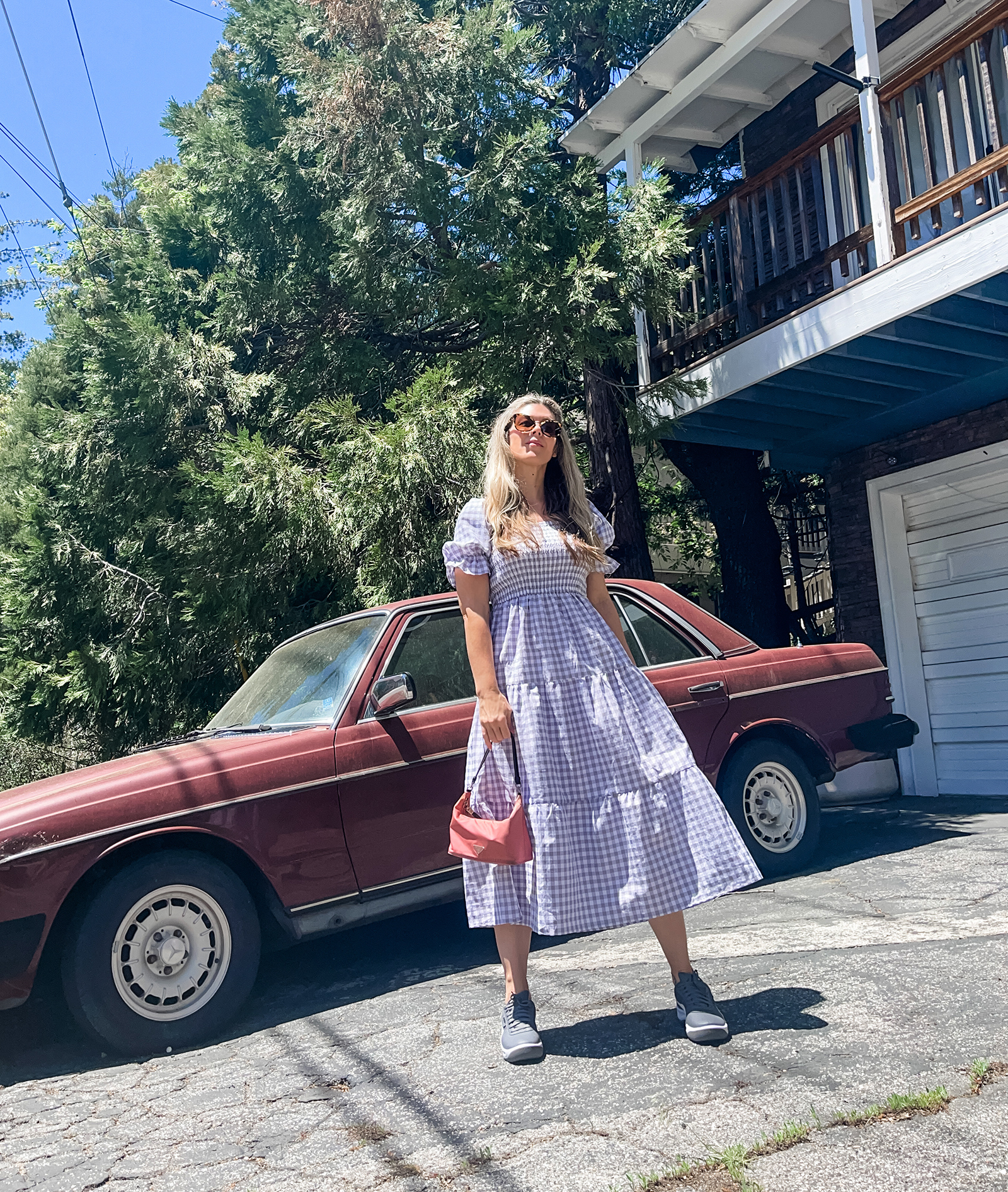 grey and white midi gingham dress with puff sleeves and tiers with vintage pink prada nylon bag and gray puma california casual sneakers in lake arrowhea