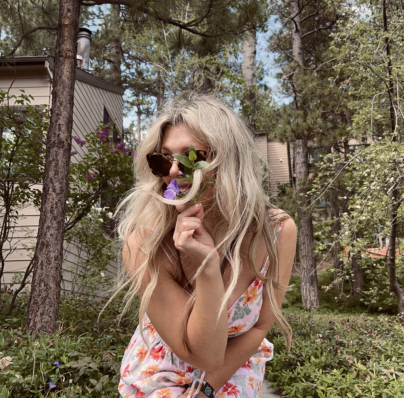 pink tropical print cut out romper for spring and summer cute and feminine with white crocs and vintage nylon prada bag with long dirty blonde beach waves hair style