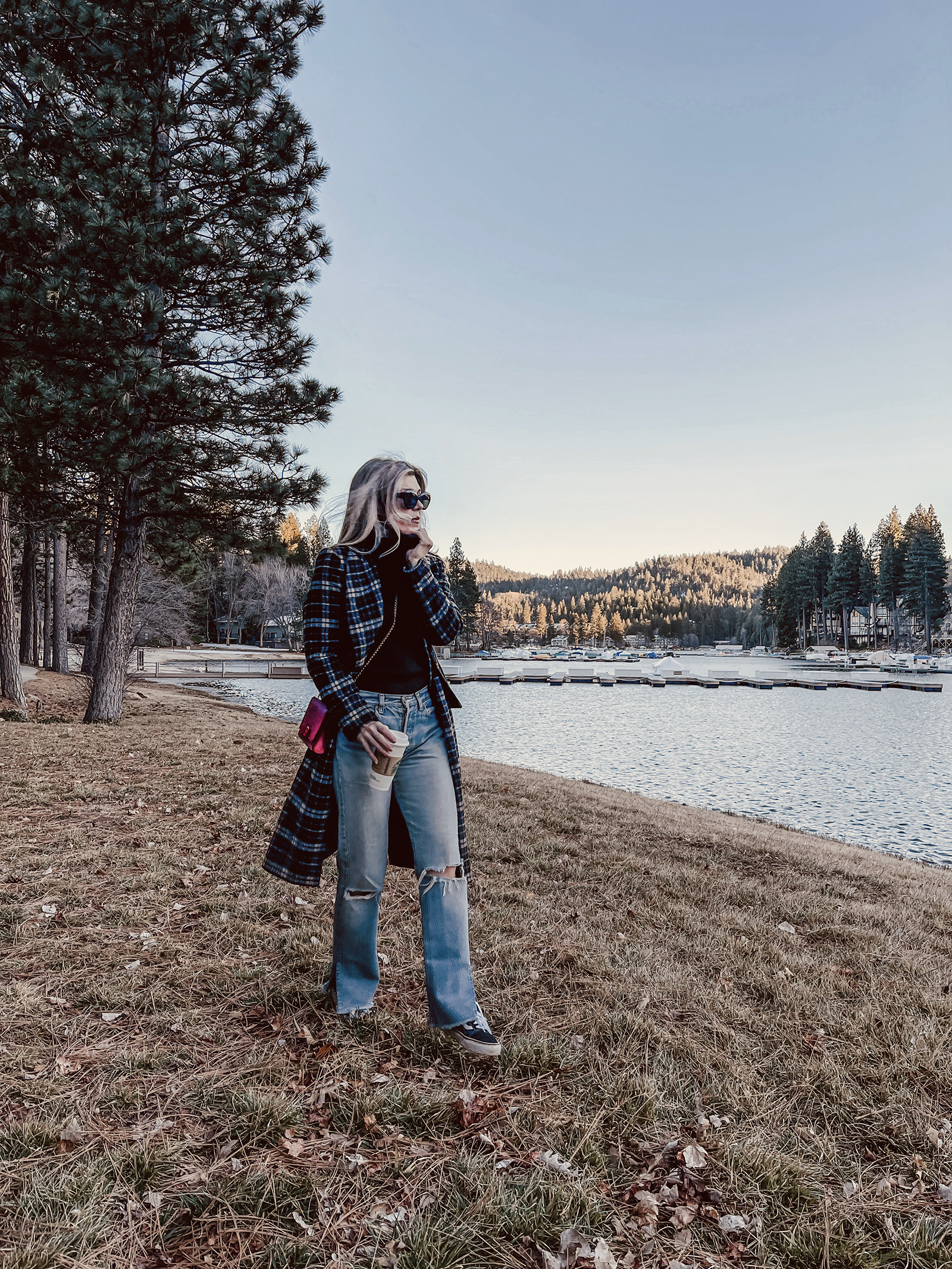 late winter outfit by the lake in vintage levi's jeans with split hems and a long plaid coat with old skool vans and a red bag giving 90s style in 90s clothes I've had since the 90s