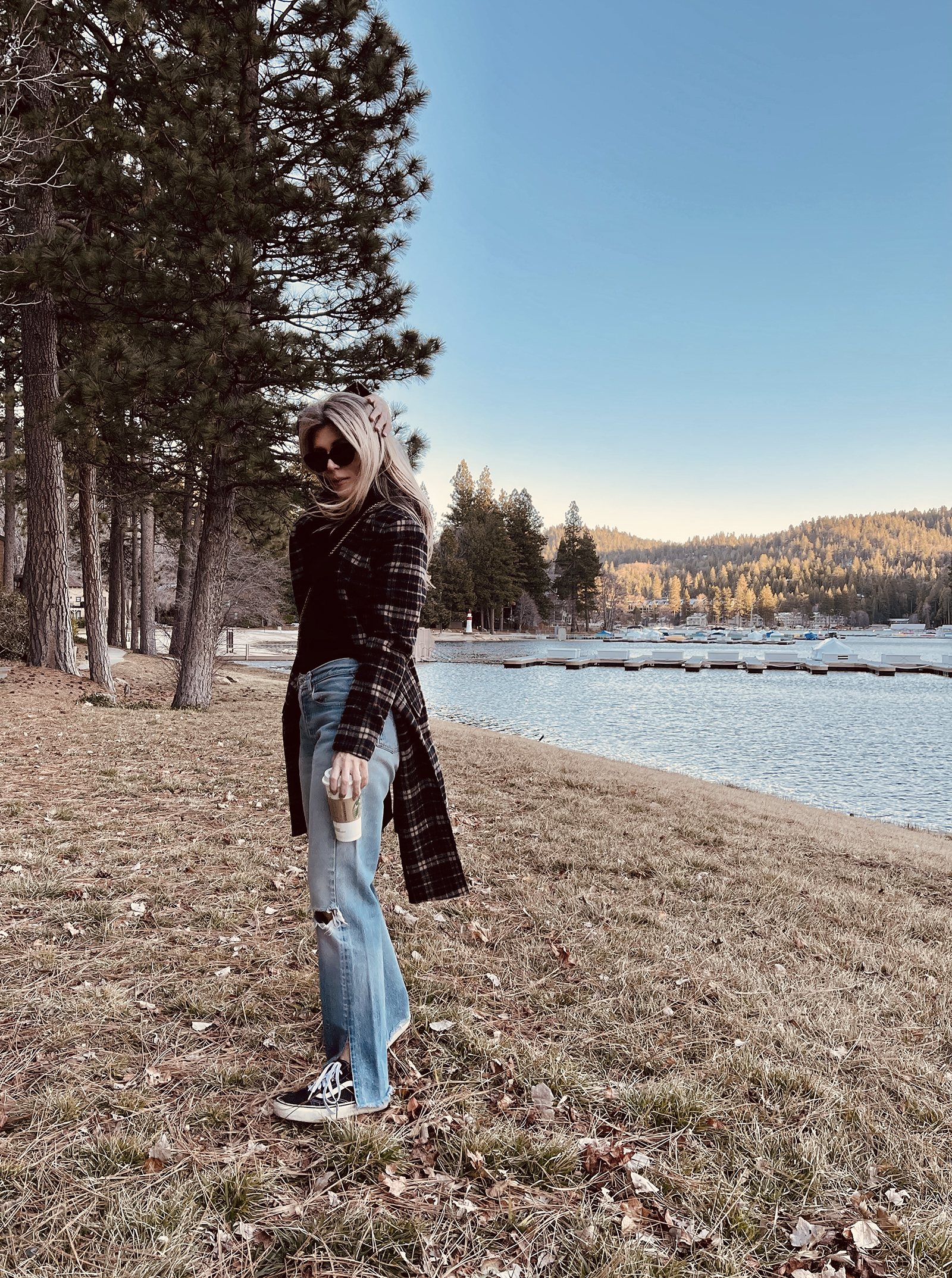 late winter outfit by the lake in vintage levi's jeans with split hems and a long plaid coat with old skool vans and a red bag giving 90s style in 90s clothes I've had since the 90s