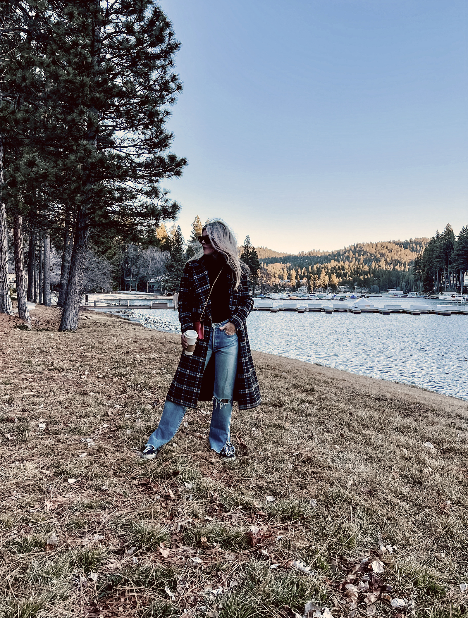 late winter outfit by the lake in vintage levi's jeans with split hems and a long plaid coat with old skool vans and a red bag giving 90s style in 90s clothes I've had since the 90s