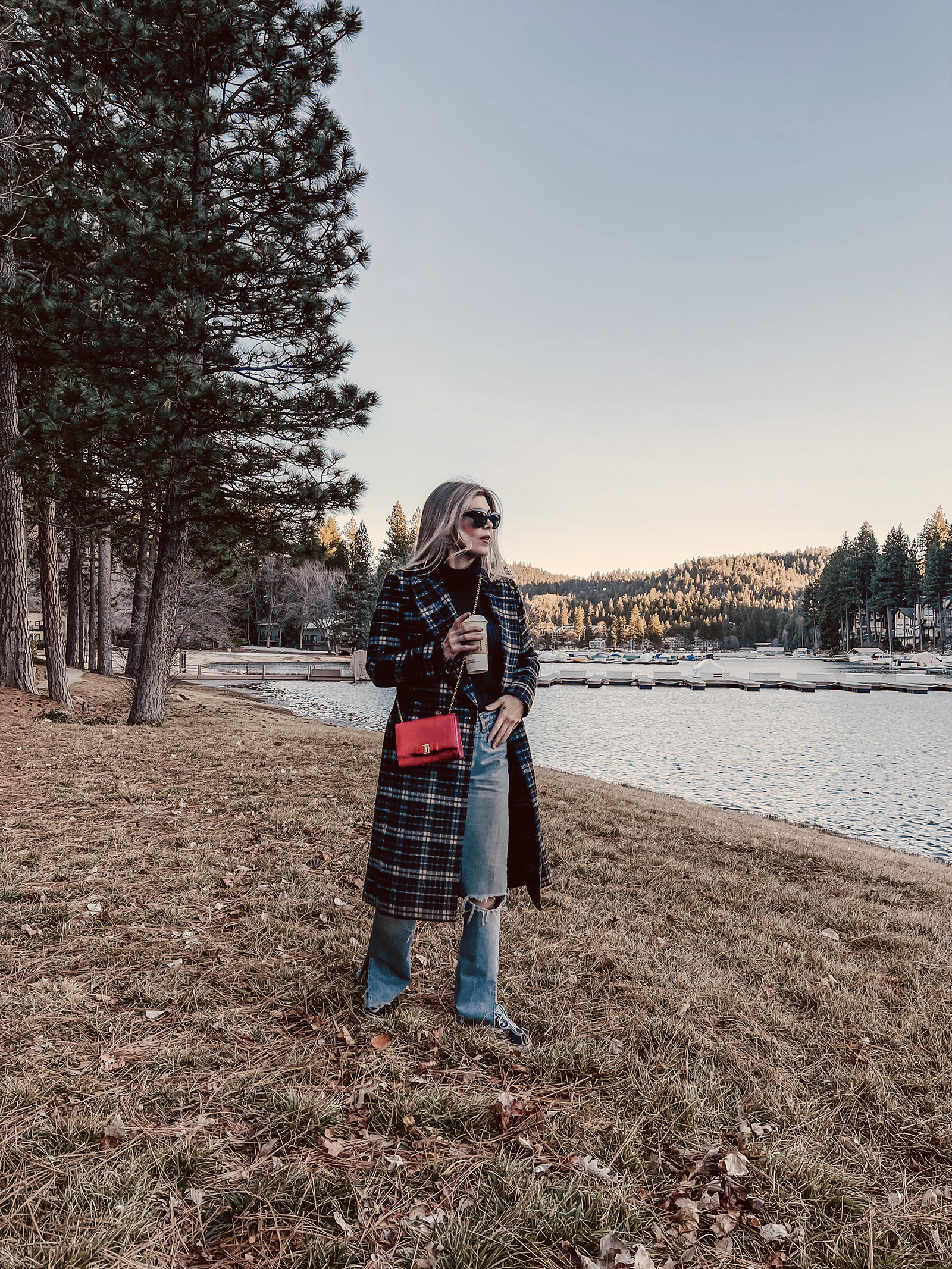 late winter outfit by the lake in vintage levi's jeans with split hems and a long plaid coat with old skool vans and a red bag giving 90s style in 90s clothes I've had since the 90s