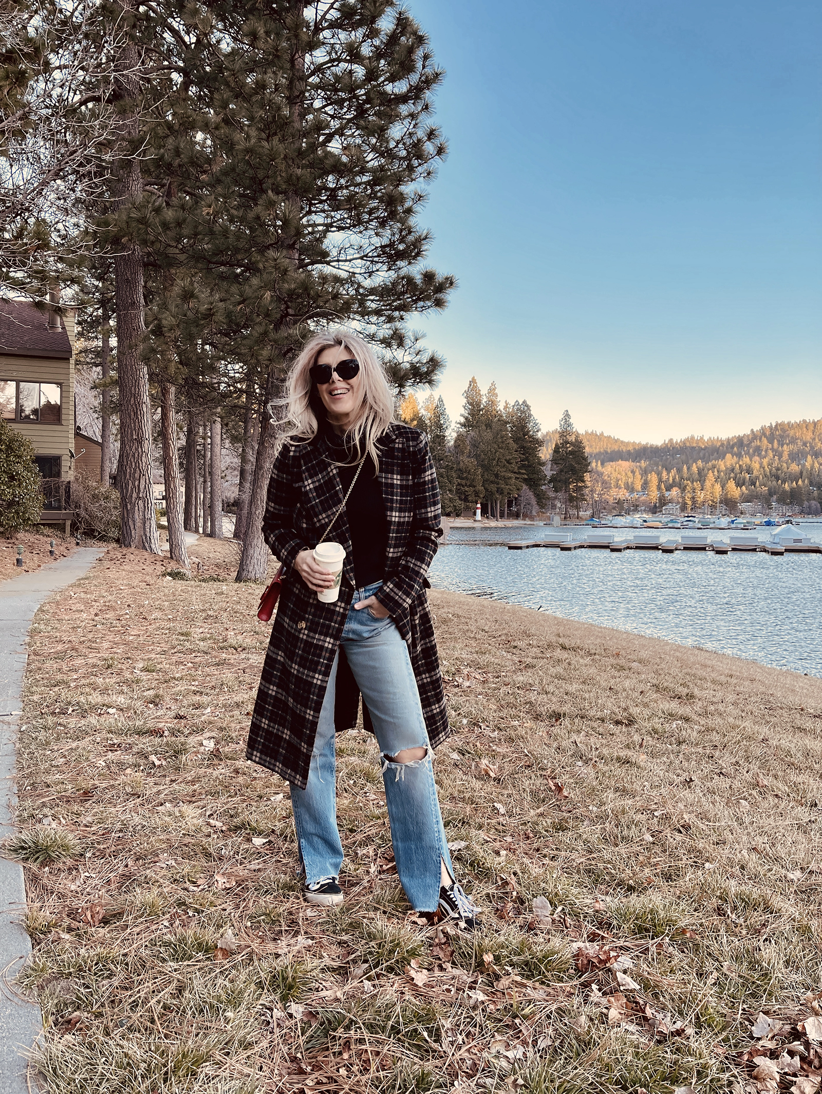 late winter outfit by the lake in vintage levi's jeans with split hems and a long plaid coat with old skool vans and a red bag giving 90s style in 90s clothes I've had since the 90s