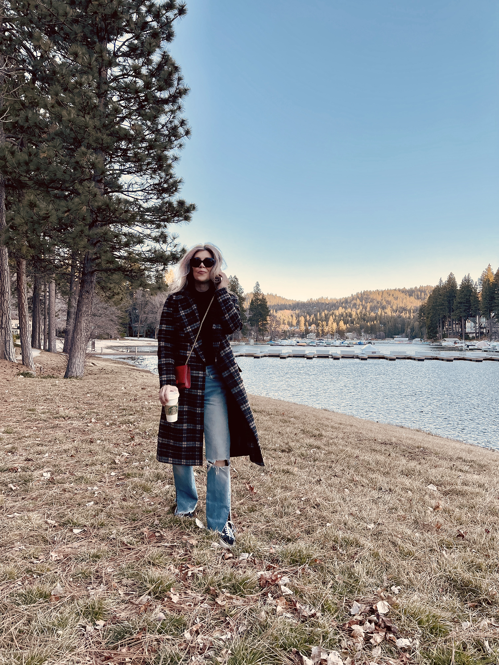 late winter outfit by the lake in vintage levi's jeans with split hems and a long plaid coat with old skool vans and a red bag giving 90s style in 90s clothes I've had since the 90s