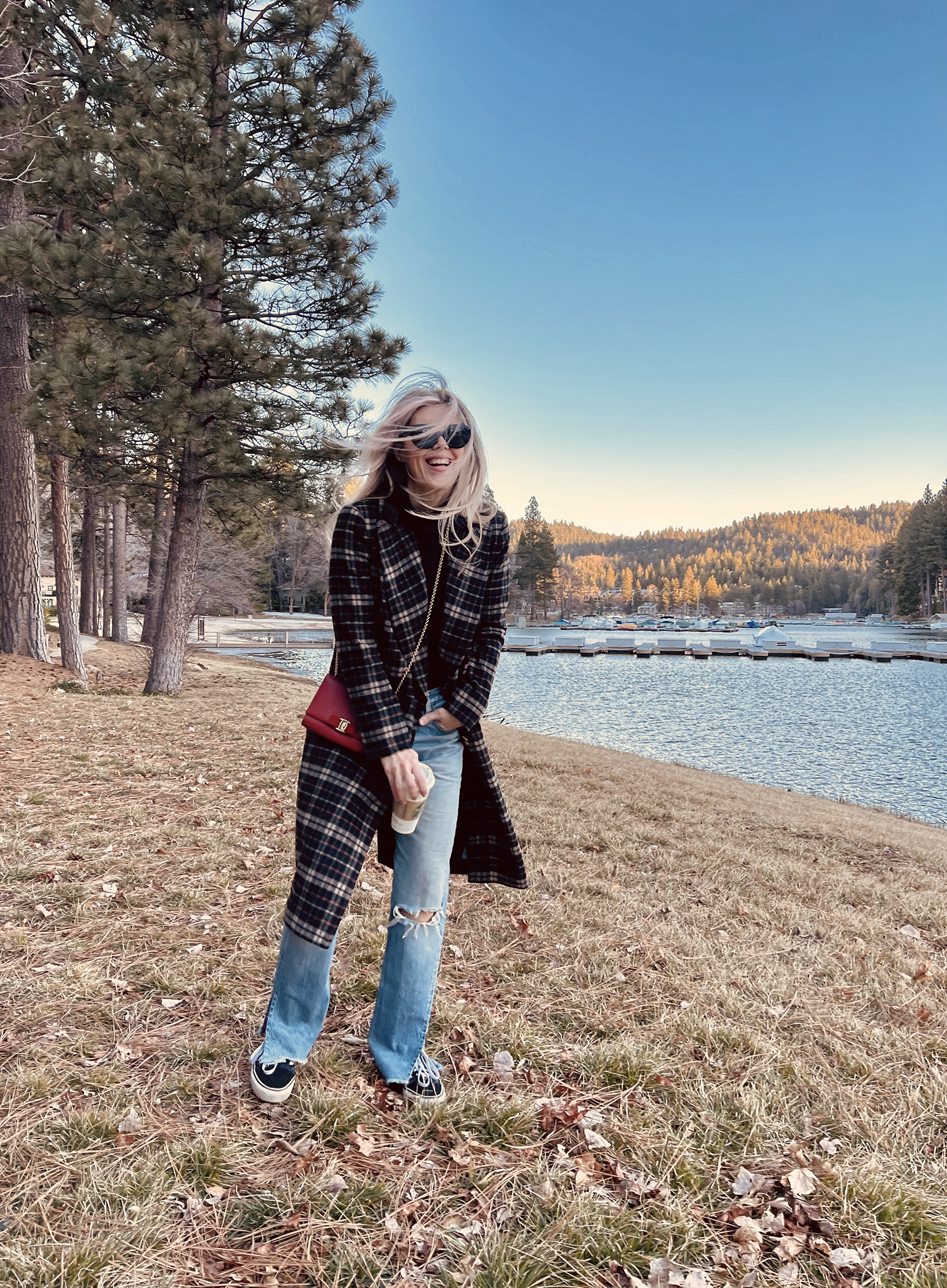 late winter outfit by the lake in vintage levi's jeans with split hems and a long plaid coat with old skool vans and a red bag giving 90s style in 90s clothes I've had since the 90s