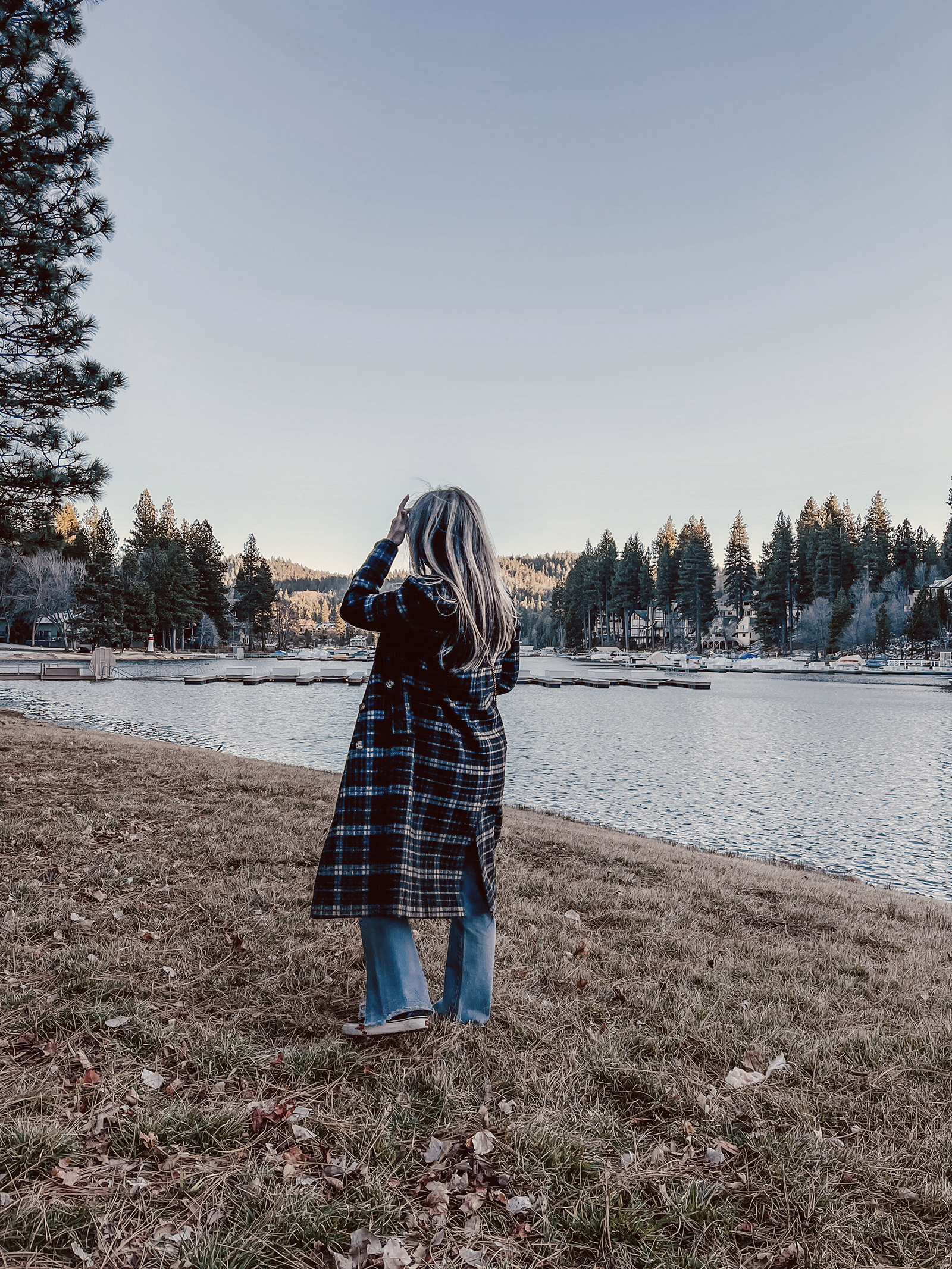 late winter outfit by the lake in vintage levi's jeans with split hems and a long plaid coat with old skool vans and a red bag giving 90s style in 90s clothes I've had since the 90s