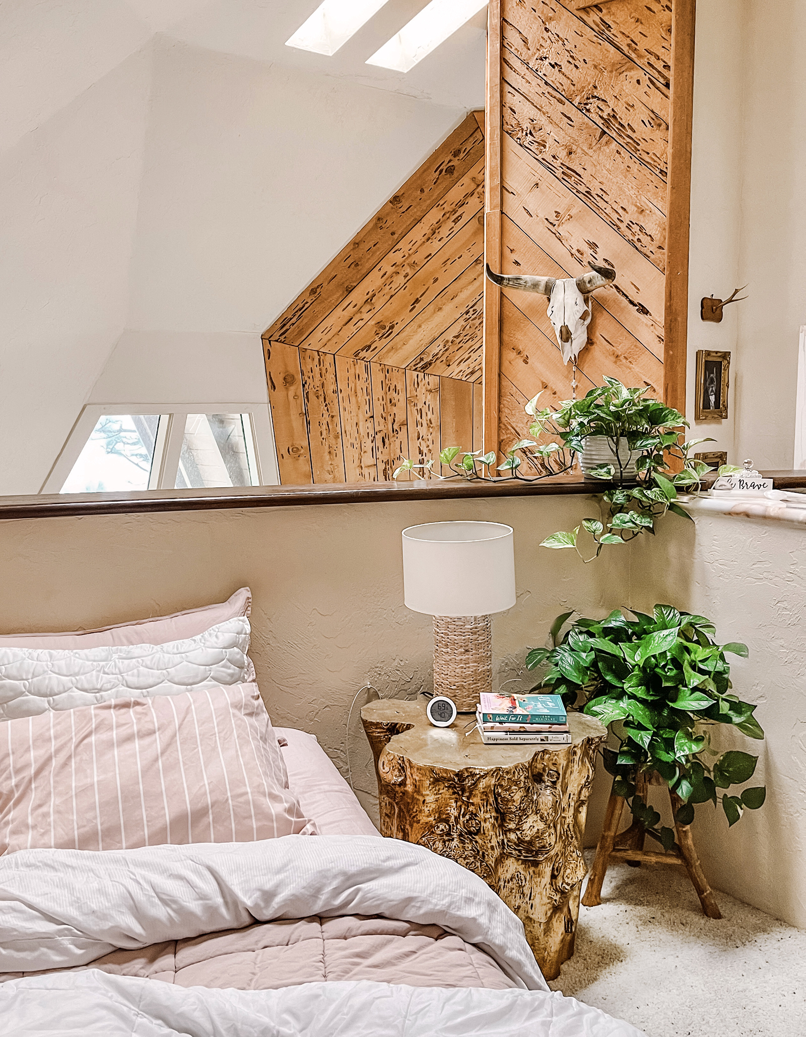 80s style bedroom loft in dome house with pink bed and gold stump nightstand and plants