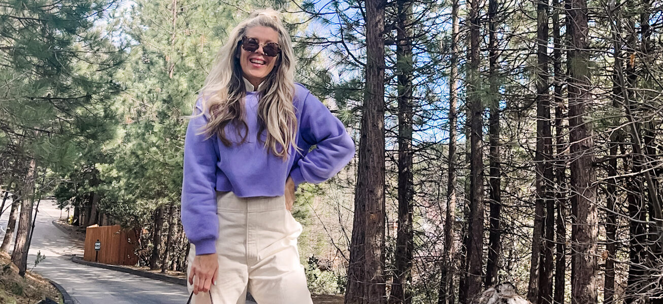 colorful spring outfit with ivory coveralls jumpsuit with lavender cropped sweatshirt pink prada nylon bag and nike sky hi