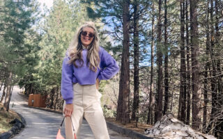 colorful spring outfit with ivory coveralls jumpsuit with lavender cropped sweatshirt pink prada nylon bag and nike sky hi