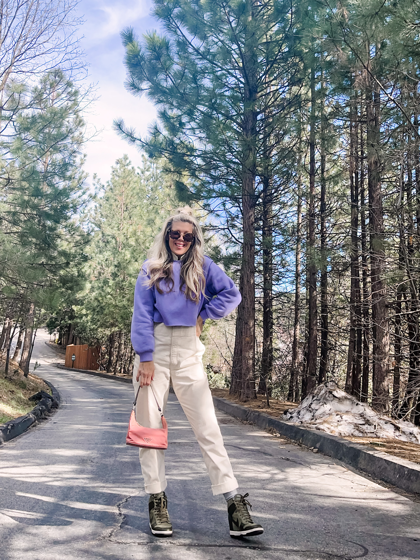 cute spring style in coveralls, lee jeans union-alls jumpsuit in ivory with lavender cropped sweatshirt, pink prada bag and nike sky high sneakers