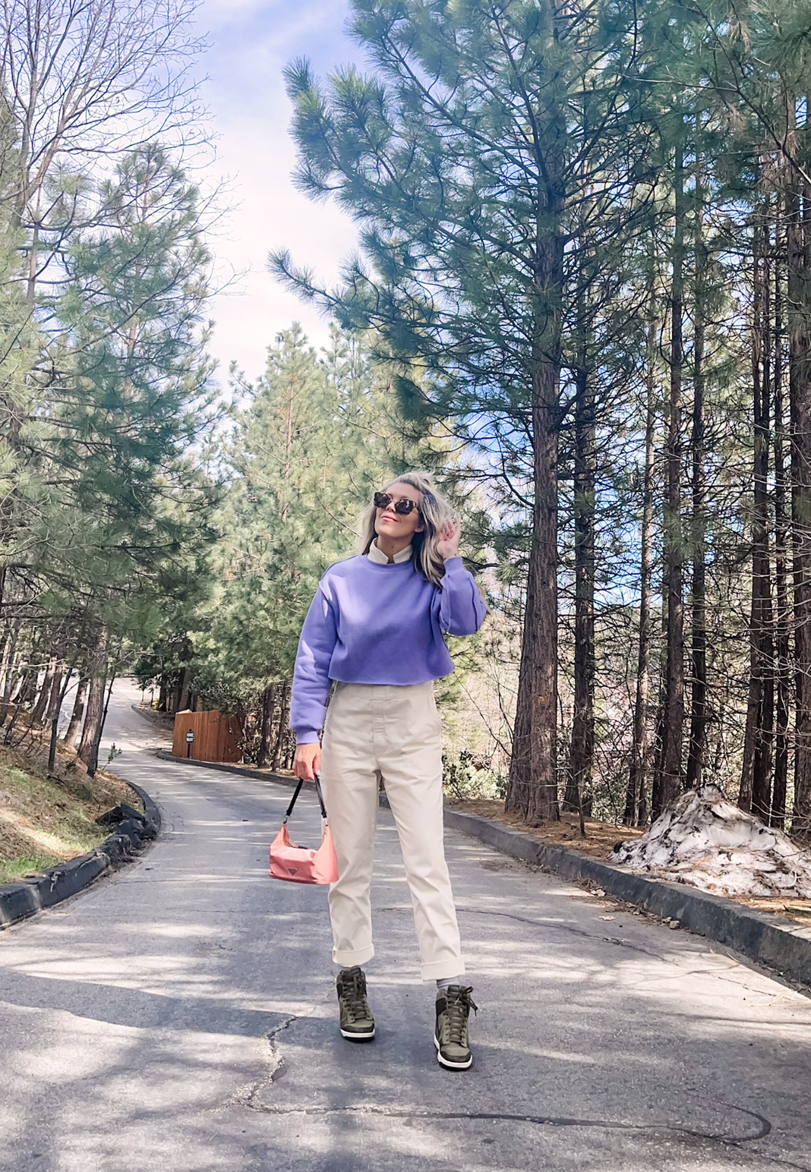 cute spring style in coveralls, lee jeans union-alls jumpsuit in ivory with lavender cropped sweatshirt, pink prada bag and nike sky high sneakers