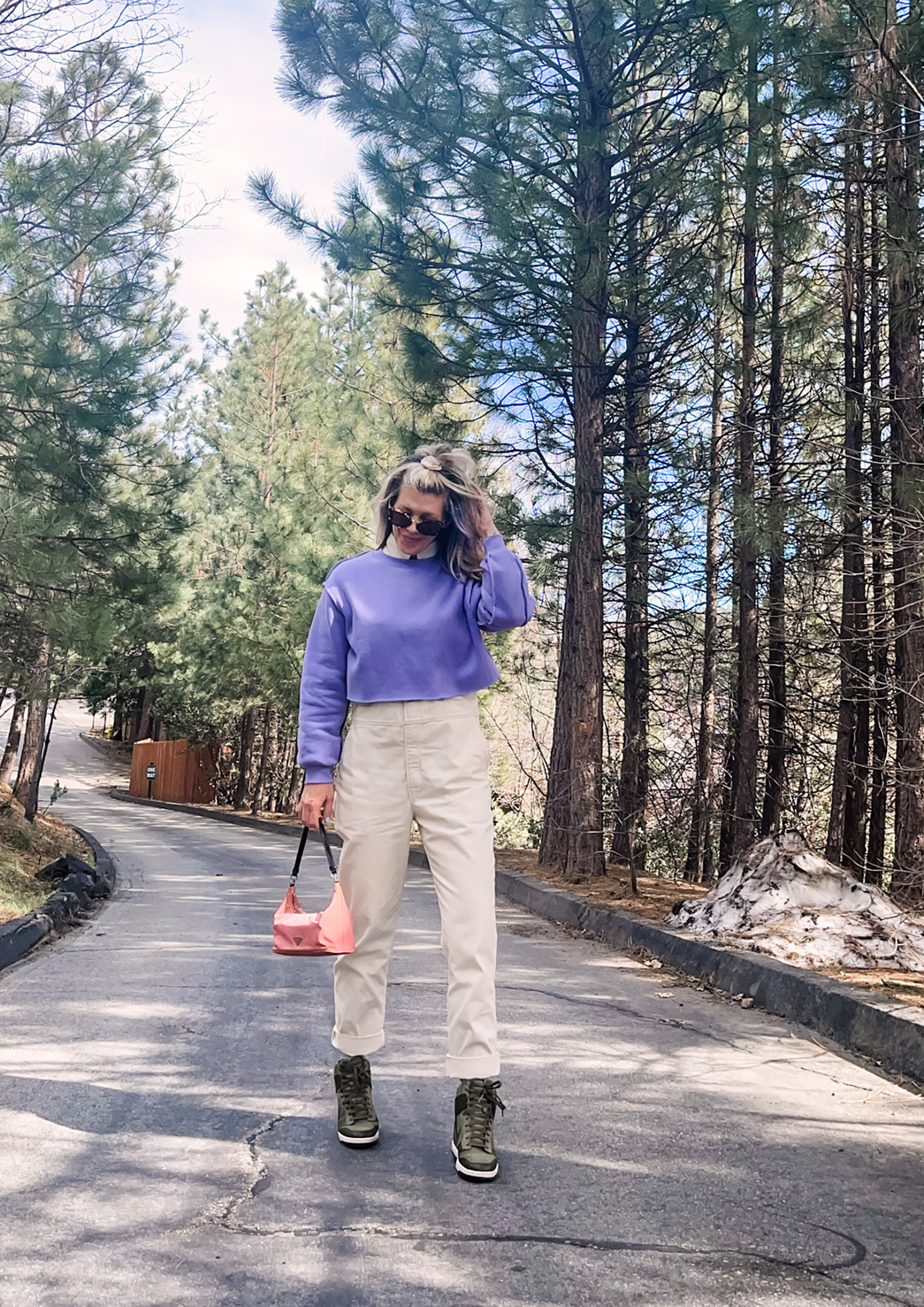 cute spring style in coveralls, lee jeans union-alls jumpsuit in ivory with lavender cropped sweatshirt, pink prada bag and nike sky high sneakers