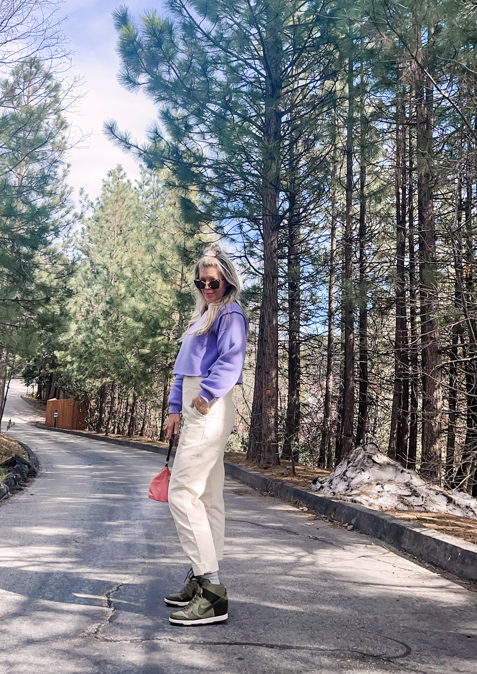 cute spring style in coveralls, lee jeans union-alls jumpsuit in ivory with lavender cropped sweatshirt, pink prada bag and nike sky high sneakers