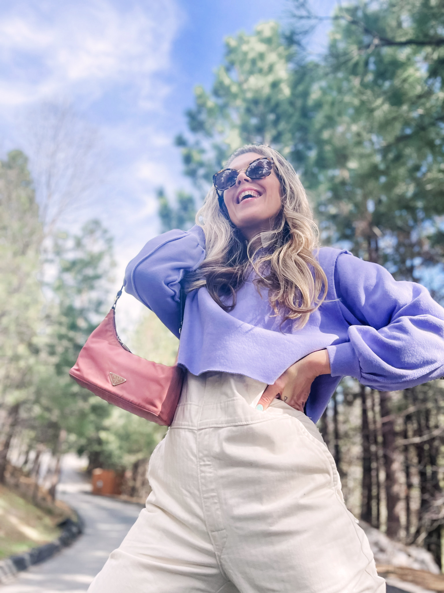 cute spring style in coveralls, lee jeans union-alls jumpsuit in ivory with lavender cropped sweatshirt, pink prada bag and nike sky high sneakers