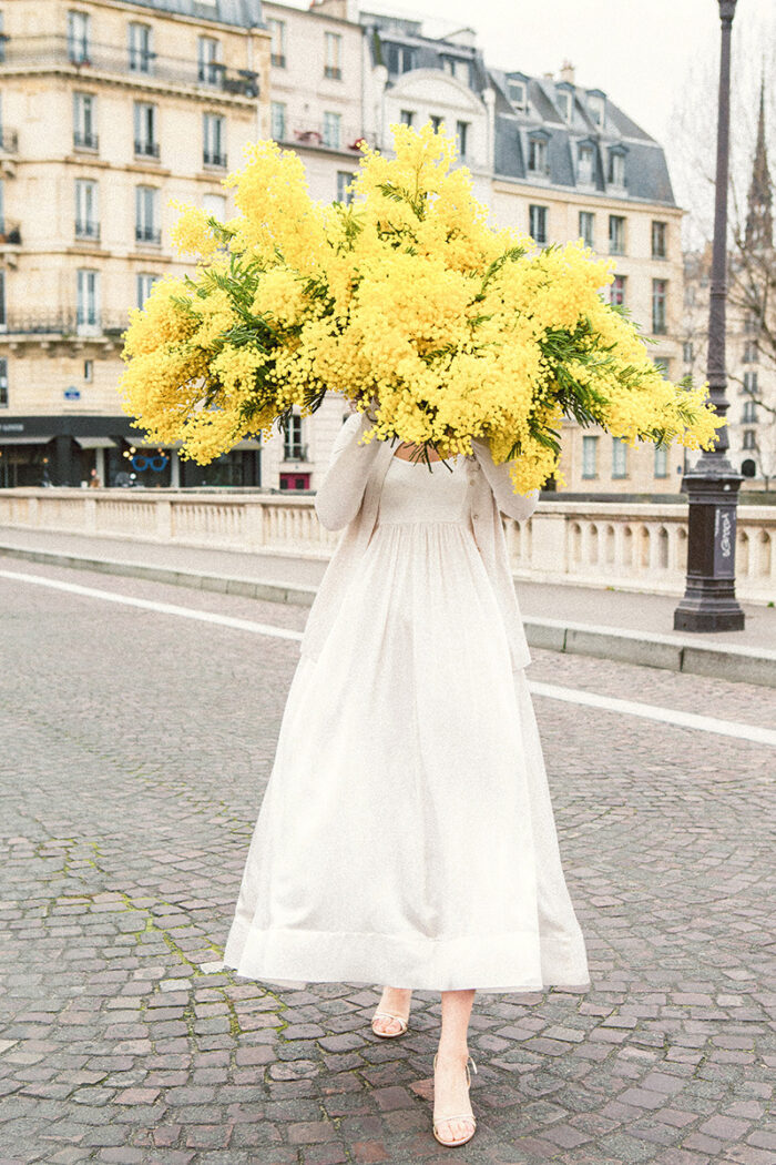 girls carrying flowers over their face