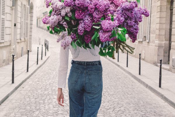 girls carrying flowers over their face