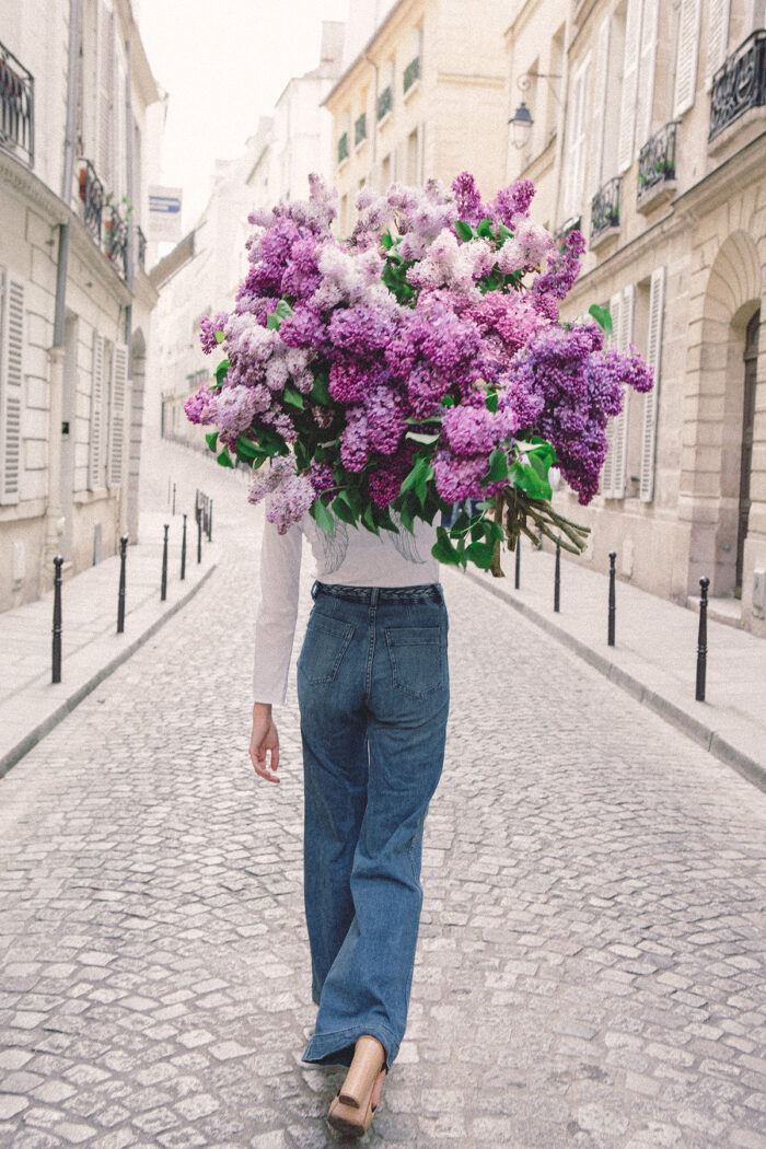 girls carrying flowers over their face