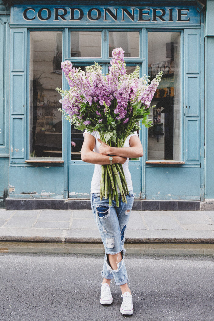 girls carrying flowers over their face