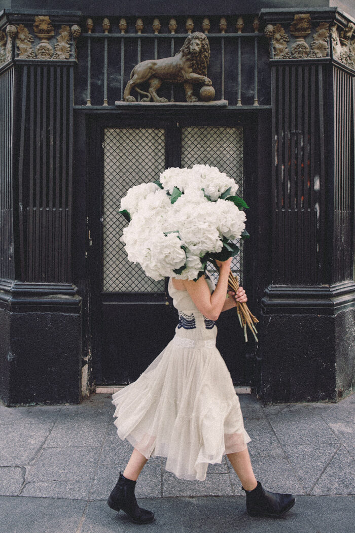 girls carrying flowers over their face