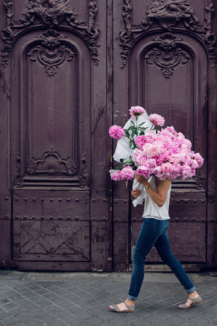 girls carrying flowers over their face